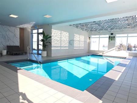 2 chambres à coucher 1 salle de bain avec DOUBLE GARAGE. piscine intérieur et gym