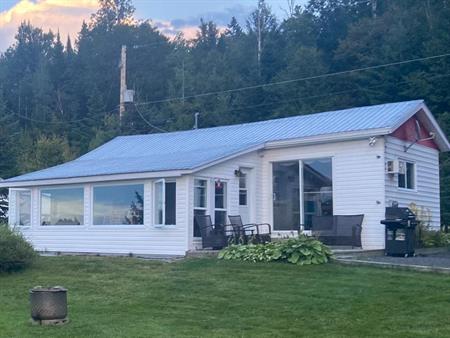 Petit chalet au bord d'un lac naturel tranquille ensemencé de truites