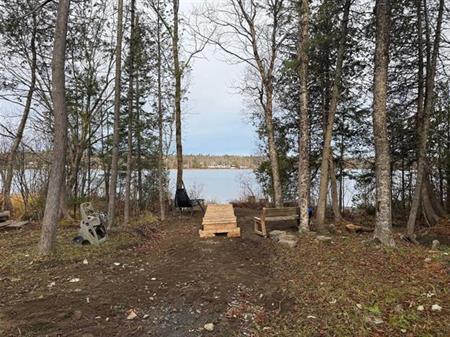 Petit Lac Lambton, Estrie. Terrain aménagé de 16 943 pi.ca. directement au bord de l’eau. Beau rivage, baignable et navigable